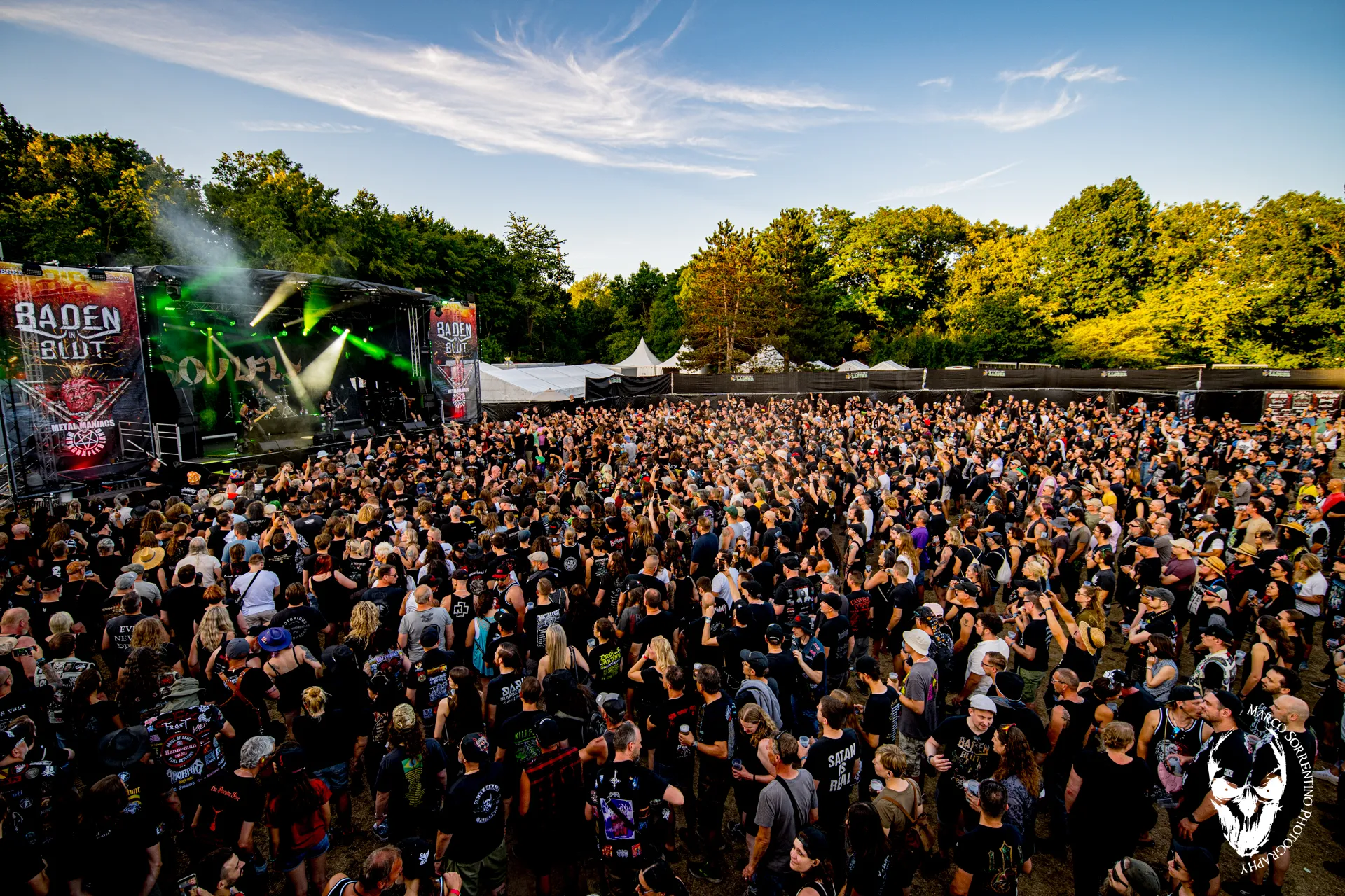 Volles Festivalgelände bei Sonne, Blick über die Menge zur Bühne